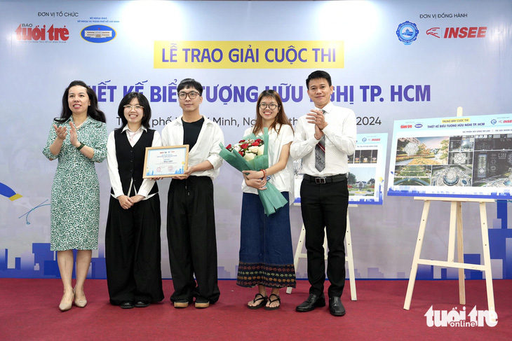 Giám khảo Phạm Trần Thanh Thảo và ông Võ Hùng Thuật trao giải cho nhóm tác giả đoạt giải nhì - Ảnh: HỮU HẠNH
