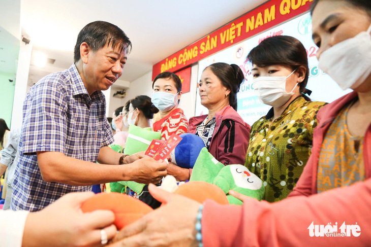 Ông  Nguyễn Văn Dũng, phó chánh văn phòng tòa soạn báo Tuổi Trẻ, trao quà cho gia đình bệnh nhi ung thư - Ảnh: PHƯƠNG QUYÊN