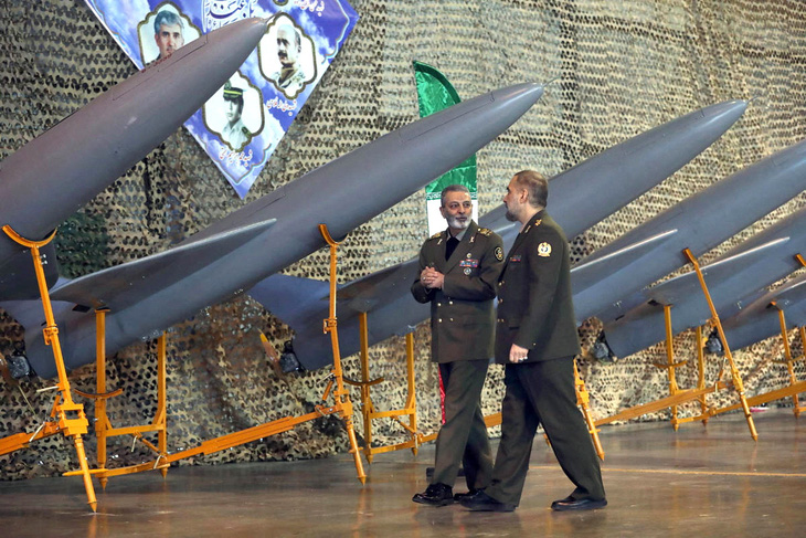 Hai sĩ quan cấp cao Iran đi ngang qua dàn máy bay không người lái của nước này ngày 22-1 - Ảnh: REUTERS