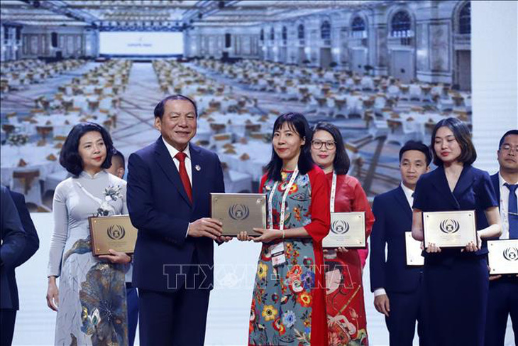 Bộ trưởng Bộ Văn hóa, Thể thao và Du lịch Việt Nam Nguyễn Văn Hùng trao giải cho đại diện một đơn vị của Việt Nam được nhận Giải thưởng Du lịch ASEAN 2024 - Ảnh: TTXVN