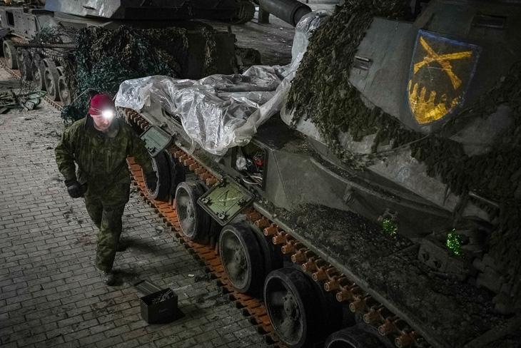 Một quân nhân Ukraine thuộc sư đoàn 92 sửa chữa pháo tự hành giữa lúc Nga tấn công Ukraine, ở khu vực Donetsk, Ukraine ngày 21-1 - Ảnh: REUTERS