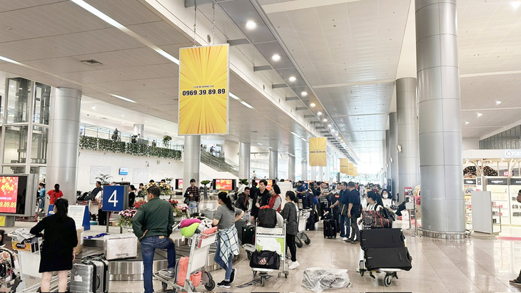 Khách nhập cảnh đợi lấy hành lý ở sân bay quốc tế Tân Sơn Nhất ngày 28-1 - Ảnh: T.L.
