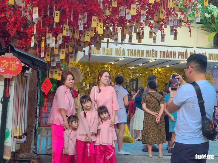 Nhà văn hóa Thanh niên TP.HCM được trang trí các tiểu cảnh cây ước nguyện, ông đồ, mai vàng... thu hút đông đúc gia đình, bạn trẻ tới chụp hình Tết - Ảnh: NHẬT XUÂN