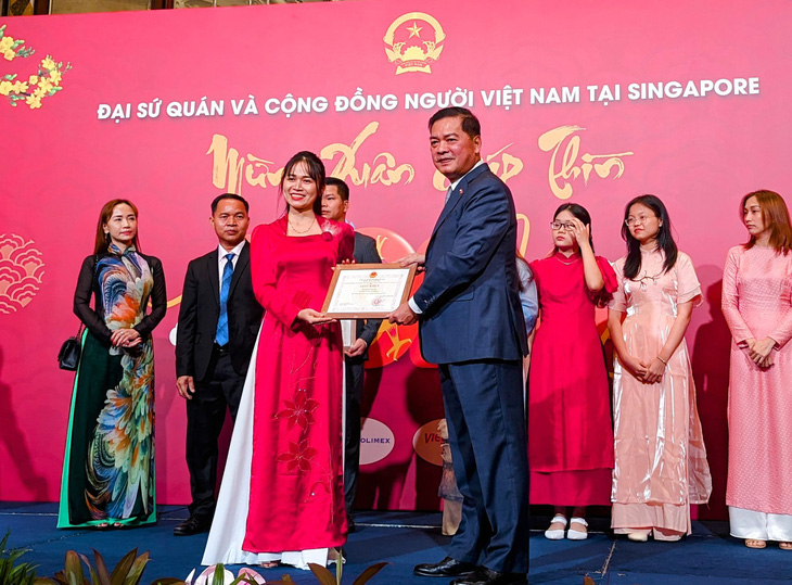 Đại sứ Mai Phước Dũng (phải) trao tặng giấy khen cho cá nhân, đơn vị trong cộng đồng đã có những đóng góp tích cực, nổi bật trong năm 2023 tới các hoạt động, chương trình của cộng đồng tại Singapore - Ảnh: LÊ NAM