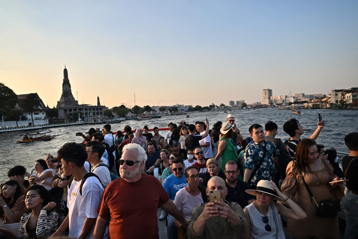 Khách du lịch và dân địa phương ngắm cảnh từ tàu du lịch trên sông Chao Phraya ở Bangkok (Thái Lan) vào ngày 27-12-2023 - Ảnh: AFP