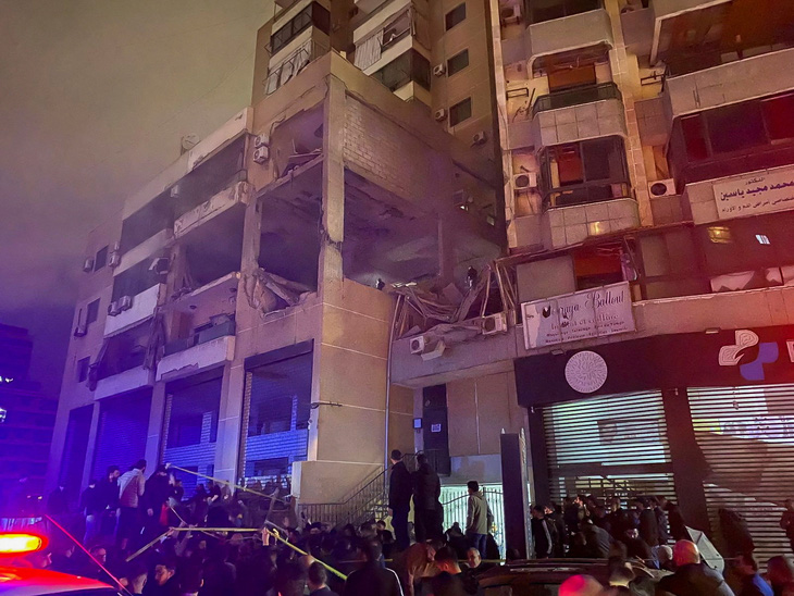 Mọi người tập trung gần một địa điểm bị hư hại sau một vụ nổ tại vùng ngoại ô Dahiyeh của Beirut, Lebanon, ngày 2-1. Theo nguồn tin an ninh Reuters, đây là một cuộc tấn công bằng máy bay không người lái của Israel - Ảnh: REUTERS