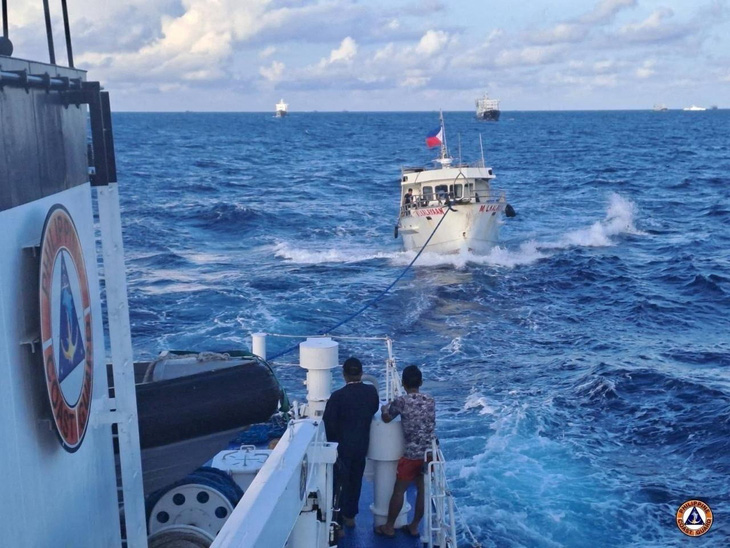 Một tàu tuần duyên Philippines lai dắt một tàu tiếp vận của nước này bị hư hại do vòi rồng của tàu hải cảnh Trung Quốc hôm 10-12-2023 - Ảnh: REUTERS