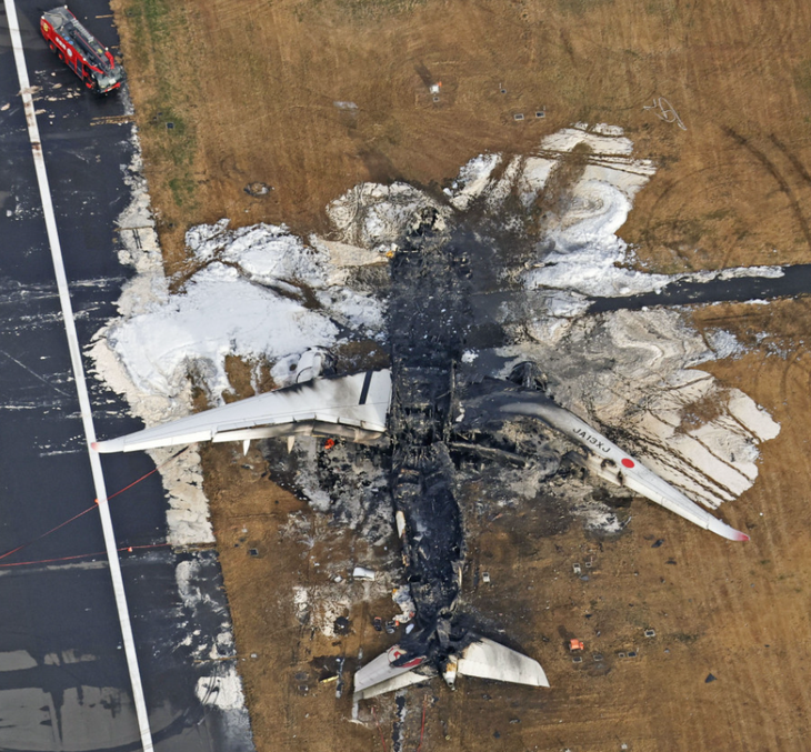 Hiện trường ngày 3-1 của máy bay thuộc Japan Airlines bốc cháy sau va chạm với máy bay tuần duyên tại sân bay Haneda - Ảnh: KYODO NEWS
