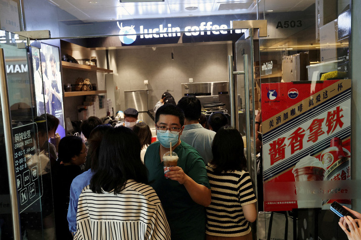 Hàng ngàn cửa hàng cà phê có thương hiệu tại Trung Quốc đã &quot;mọc lên như nấm&quot; trong những tháng gần đây. Trong ảnh: Một khách hàng bước ra khỏi cửa hàng Luckin Coffee ở Bắc Kinh, Trung Quốc, ngày 4-9-2023. Ảnh: reuters.com