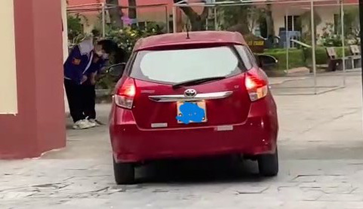 Hai học sinh Trường THCS Trần Mai Ninh, TP Thanh Hóa đứng ở cổng trường cúi chào khi ô tô đi vào cổng trường - Ảnh cắt từ video trên mạng xã hội