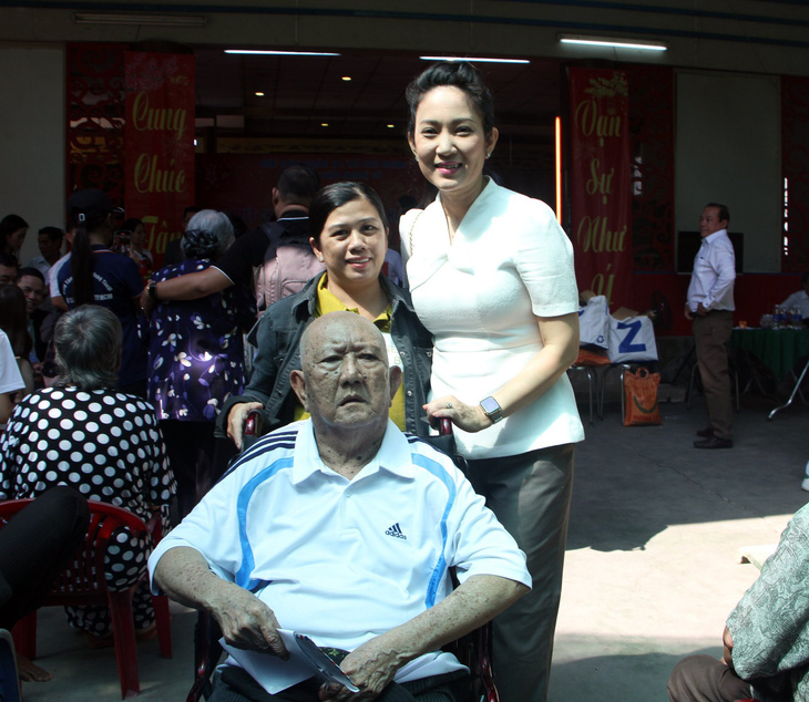 Bà Thanh Thúy (bìa phải) - phó giám đốc Sở Văn hóa và Thể thao TP.HCM - phụ đẩy xe lăn cho nghệ sĩ Mạc Can - Ảnh: THÙY TRANG