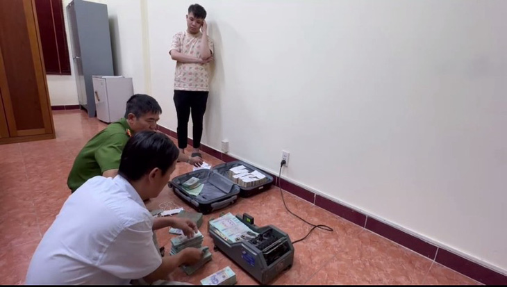 Lực lượng chức năng đang kiểm đếm tiền tang vật của Nguyễn Hữu Thái - Ảnh: Công an cung cấp