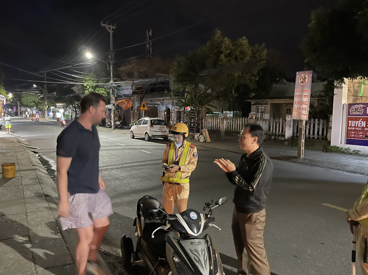 Công an TP Hội An làm việc với người nước ngoài di chuyển trên đường bằng xe máy - Ảnh: Q.H.
