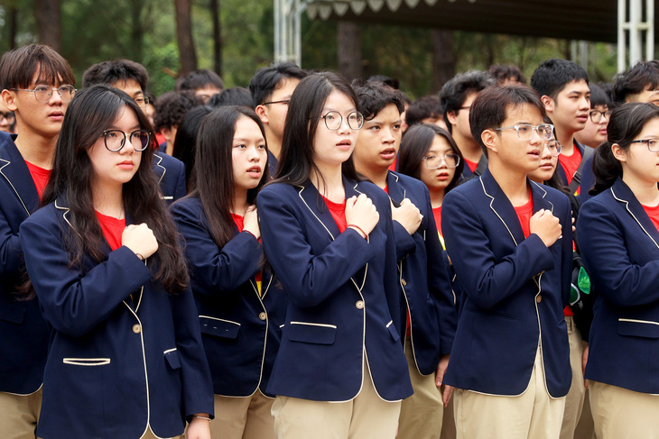 Học sinh Trường THPT Phan Huy Chú, Hà Nội, chào cờ và hát Quốc ca tại nghĩa trang Trường Sơn - Ảnh: HUY TRẦN