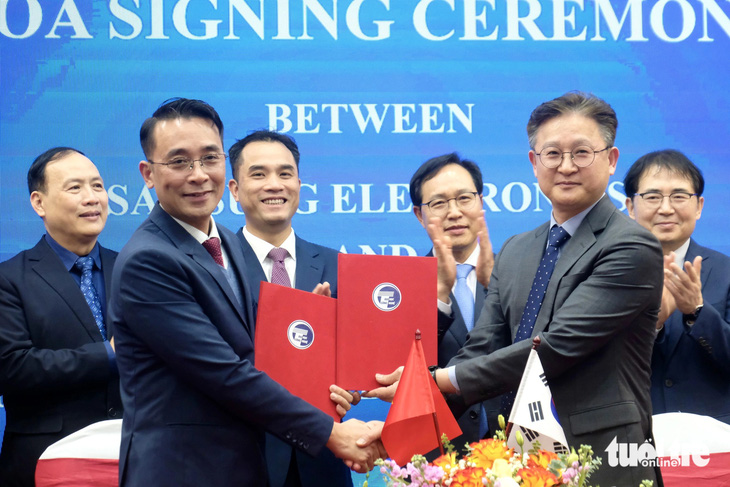 GS.TS Chử Đức Trình, hiệu trưởng Trường đại học Công nghệ (thứ hai từ trái) và ông Chang Yong Kim - phó tổng giám đốc Samsung Electronics - thực hiện ký thỏa thuận - Ảnh: NGUYÊN BẢO