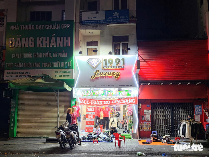 Dù cả con phố đã tắt đèn, một cửa hàng thời trang trên đường Nguyễn Trãi (quận 5) vẫn &quot;ngóng&quot; những vị khách cuối cùng trong ngày - Ảnh: NHẬT XUÂN