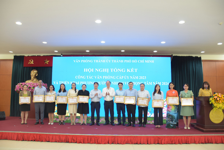 Phó bí thư thường trực Thành ủy Nguyễn Hồ Hải (giữa, bên phải) cùng Chánh Văn phòng Thành ủy Phạm Hồng Sơn (giữa, bên trái) trao bằng khen cho các cá nhân - Ảnh: CTV