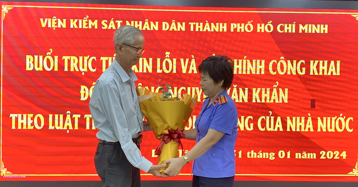 Đại diện Viện kiểm sát nhân dân TP.HCM xin lỗi công khai và tặng hoa ông Nguyễn Văn Khẩn - Ảnh: TUYẾT MAI