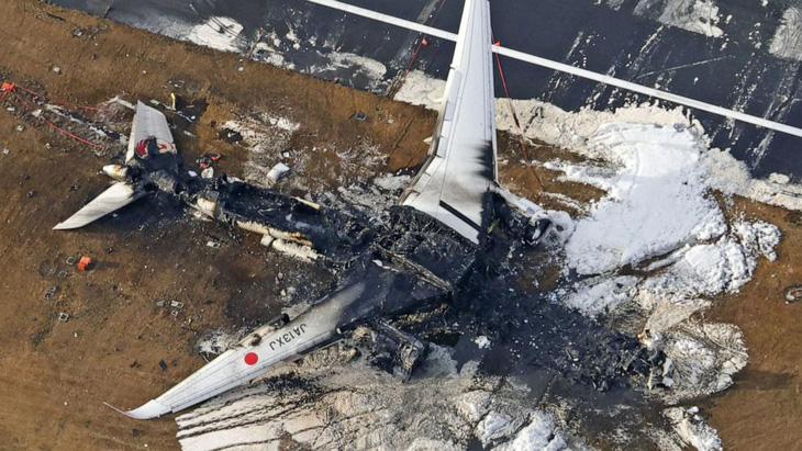 Ảnh chụp từ trên không cho thấy chiếc máy bay Airbus A350 của Japan Airlines bị cháy rụi sau khi va chạm với máy bay cảnh sát biển Nhật Bản tại sân bay quốc tế Haneda ở Tokyo - Ảnh: KYODO