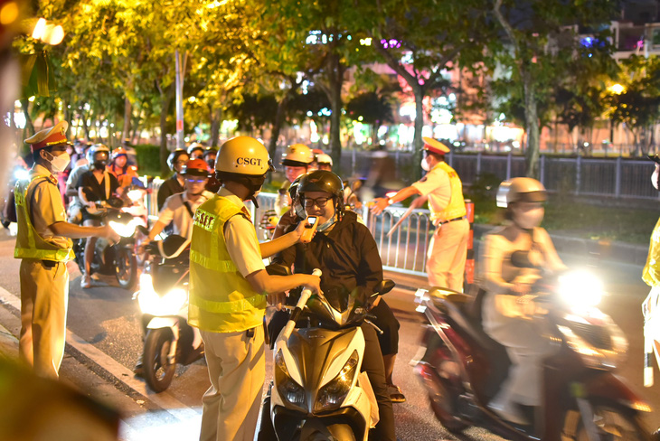 CSGT đo nồng độ cồn của người lái xe máy trên dường Hoàng Sa, quận 1, TP.HCM - Ảnh: T.T.D.