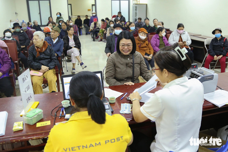 Cô Nguyễn Thị Quế (giữa) phấn khởi khi nhận lương hưu hai tháng liền - Ảnh: HÀ QUÂN