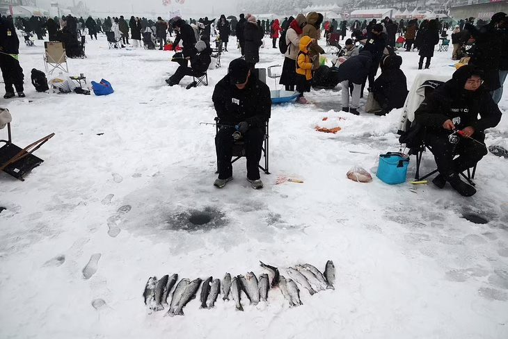 Câu cá trên sông băng ở lễ hội Sancheoneo Hwacheon, Hàn Quốc, tháng 1-2023. Ảnh tư liệu: reuters.com