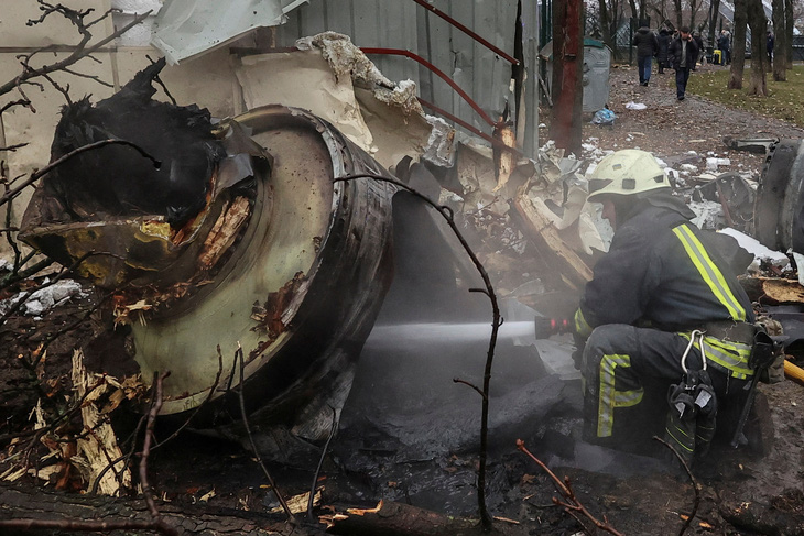 Lính cứu hỏa dập tắt lửa từ phần còn lại của tên lửa không xác định, mà chính quyền Kiev tuyên bố là do Triều Tiên sản xuất, ở Kharkov, Ukraine, ngày 2-1 - Ảnh: REUTERS