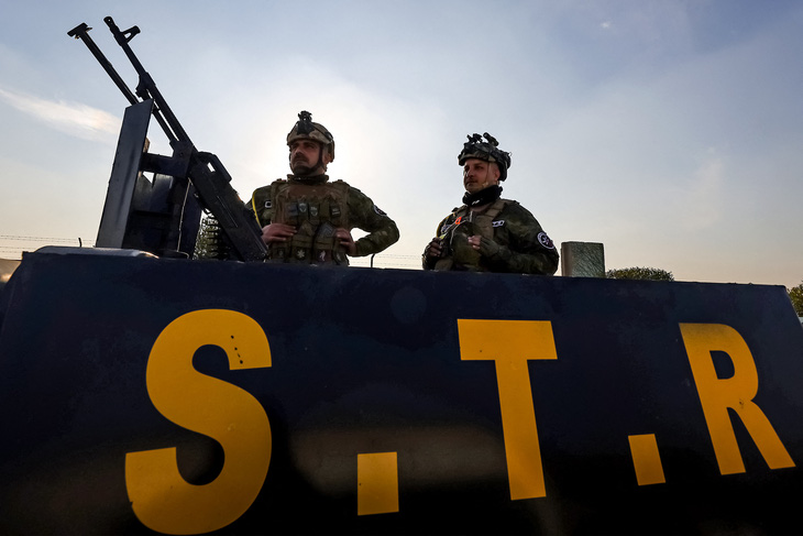 Các thành viên của lực lượng an ninh Iraq đứng gác trên xe bọc thép ở Baghdad vào ngày 4-1 - Ảnh: AFP