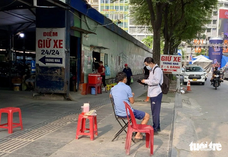 Điểm giữ xe nằm trên đường Tôn Thất Thiệp, ngay cạnh phố đi bộ Nguyễn Huệ, có mức giá 15.000 - 20.000 đồng/xe - Ảnh: TIẾN QUỐC