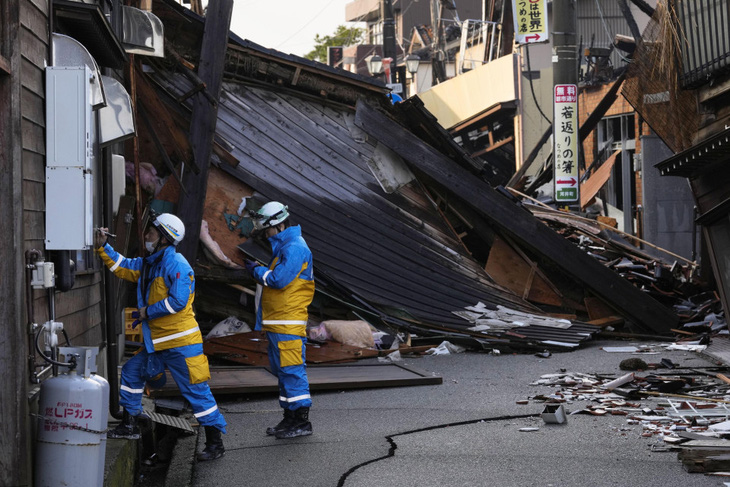 Cảnh sát tìm kiếm người bị mắc kẹt tại một ngôi nhà bị sập do động đất ở thành phố Wajima, tỉnh Ishikawa, Nhật Bản vào ngày 6-1 - Ảnh: KYODO