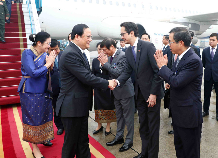 Thứ trưởng Bộ Ngoại giao Đỗ Hùng Việt (thứ hai từ phải) và các quan chức Việt Nam đón Thủ tướng Lào Sonexay Siphandone cùng phu nhân - Ảnh: TTXVN