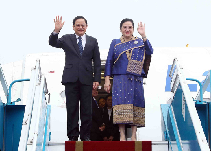 Thủ tướng Lào Sonexay Siphandone và phu nhân vẫy tay chào khi đến sân bay Nội Bài - Ảnh: TTXVN