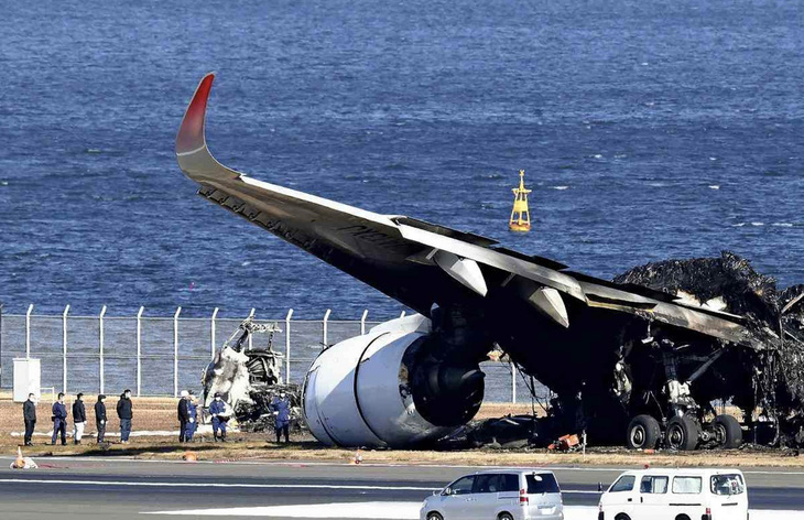 Lực lượng chức năng dọn dẹp tàn dư của chiếc Airbus A350-100 bị cháy - Ảnh: YOMIURI SHIMBUN
