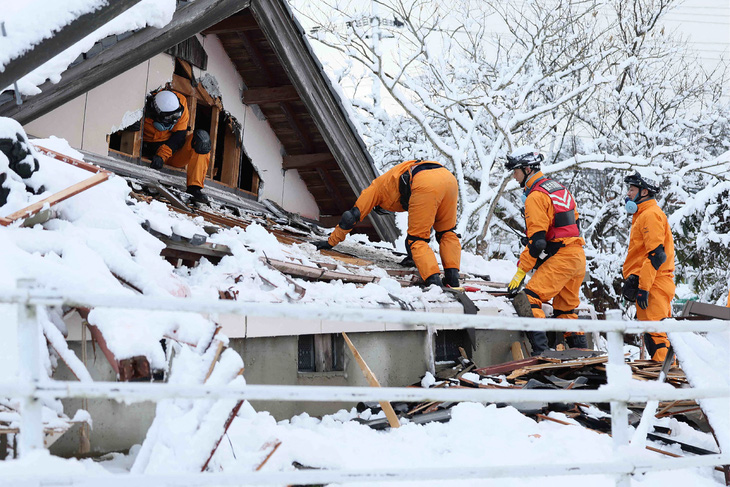 Lực lượng cứu hộ tìm kiếm người sống sót trong một ngôi nhà đổ nát sau động đất ở thành phố Suzu ngày 8-1 - Ảnh: AFP