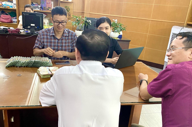 Ông Nguyễn Hoàng Nguyên - Phó tổng biên tập báo Tuổi Trẻ (bên phải), đại diện báo Tuổi Trẻ tiếp nhận và cảm ơn gia đình đã ủng hộ chương trình - Ảnh: P.Đ.