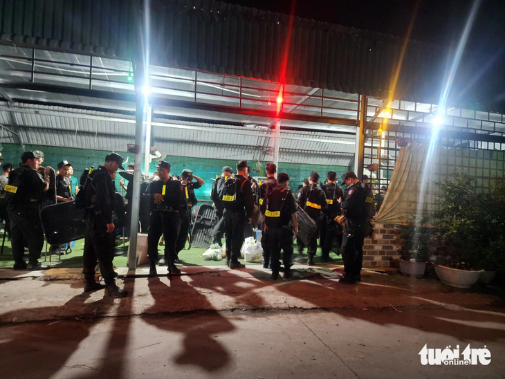 Hàng chục chiến sĩ cảnh sát cơ động tập trung tại căn nhà ven đường liên ấp (ấp 7, xã Lương Hòa, huyện Bến Lức, tỉnh Long An) vào tối 8-1 - Ảnh: NGỌC KHẢI