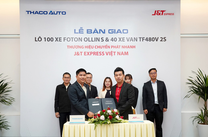 Đại diện THACO AUTO (bên trái) và đại diện J&T Express VN ký kết bàn giao 140 xe