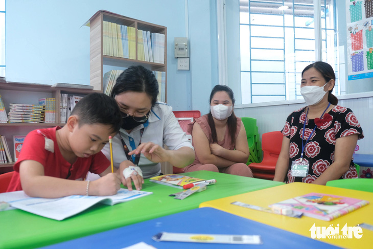 Thấy con chăm học, vui vẻ vì có các cô và bạn bè, phụ huynh cũng vui theo - Ảnh: NGỌC PHƯỢNG