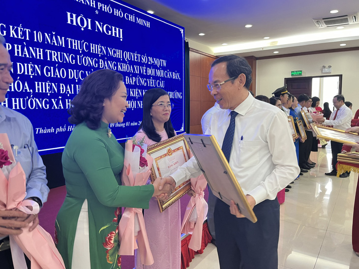 Bí thư Thành ủy TP.HCM Nguyễn Văn Nên trao bằng khen cho các tập thể, cá nhân có thành tích xuất sắc trong thực hiện nghị quyết 29 - Ảnh: MỸ DUNG