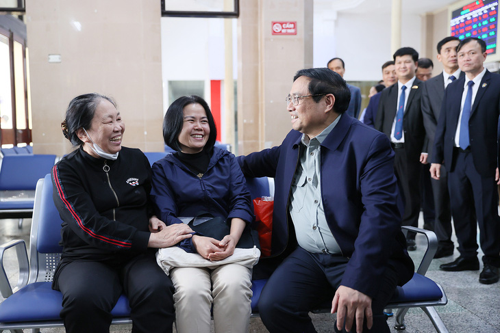 Thủ tướng &quot;phỏng vấn&quot; hai hành khách đi tàu tại ga Hà Nội trước khi đến dự hội nghị - Ảnh: VNR
