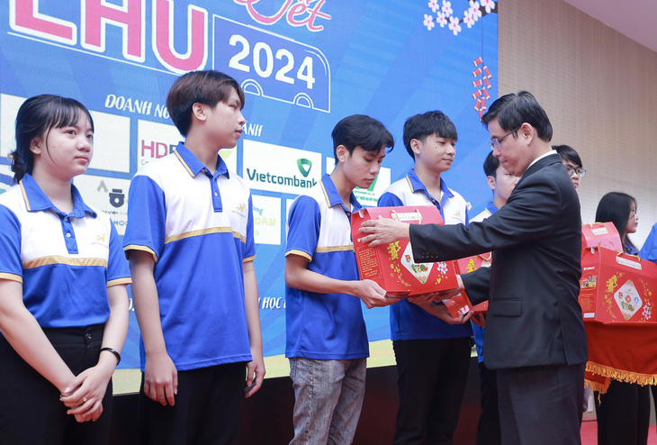 Ông Lâm Thành Hiển, hiệu trưởng Trường đại học Lạc Hồng, trao quà Tết cho sinh viên tham gia Chuyến xe về Tết 2024 - Ảnh: Q.V.