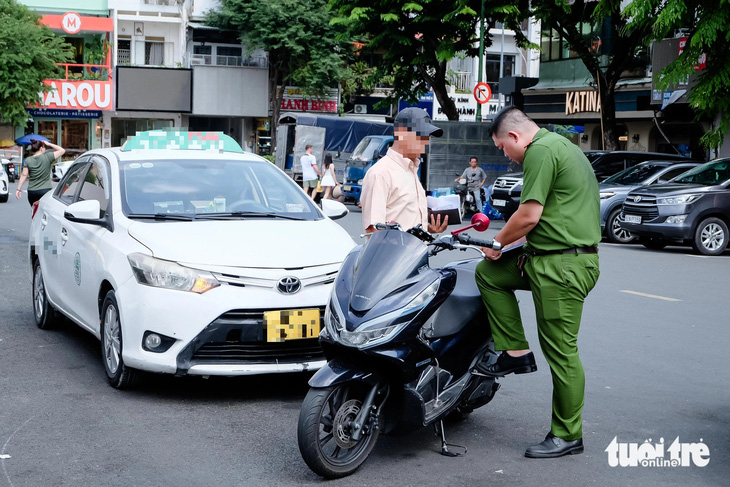 Xử lý ô tô đậu tràn lan dưới lòng đường ở trung tâm TP.HCM - Ảnh 1.