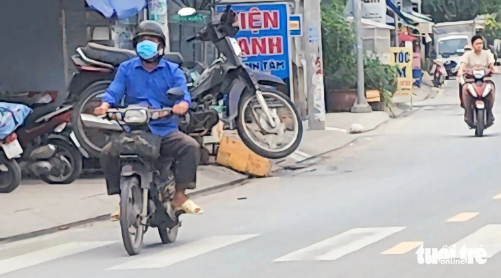 Xe máy 'cõng' hàng cồng kềnh chạy bon bon trên đường - Ảnh 1.