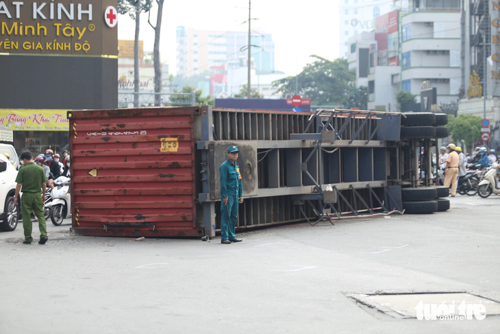 Xe container lật ngang ở vòng xoay trung tâm TP.HCM, giao thông ùn ứ nghiêm trọng - Ảnh 1.