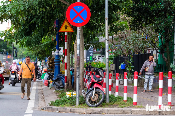 Rào chắn vỉa hè quanh tòa nhà ngăn hàng rong， hàng rong vẫn bán， người đi bộ phải xuống lòng đường - Ảnh 1.