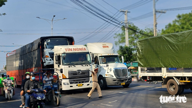 Lực lượng cảnh sát giao thông Công an tỉnh Tiền Giang xử lý 2 chiếc xe tải nặng chạy qua cầu Rạch Miễu trong giờ cấm - Ảnh: MẬU TRƯỜNG