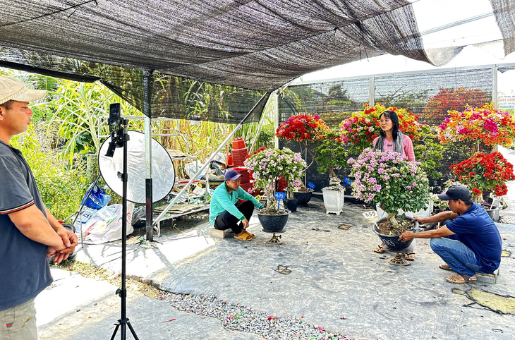 Nhóm nông dân livestream bán hoa kiểng tại cơ sở cây cảnh Sa Đéc, huyện Lấp Vò, tỉnh Đồng Tháp - Ảnh: ĐẶNG TUYẾT