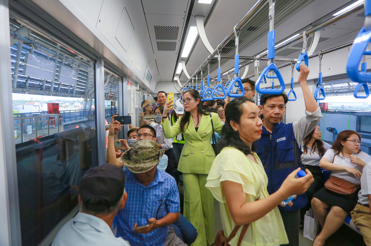 Người dân thích thú dùng điện thoại ghi lại hình ảnh trên chuyến tàu metro - Ảnh: CHÂU TUẤN