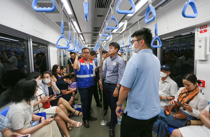 Ông Hoàng Mai Tùng - phó giám đốc Ban Quản lý dự án 1 Ban Quản lý Đường sắt đô thị TP.HCM (áo màu xanh dương) cũng có mặt trên chuyến tàu số 2 (xuất phát lúc 10h10 từ ga Suối Tiên đến ga Bến Thành) - Ảnh: CHÂU TUẤN