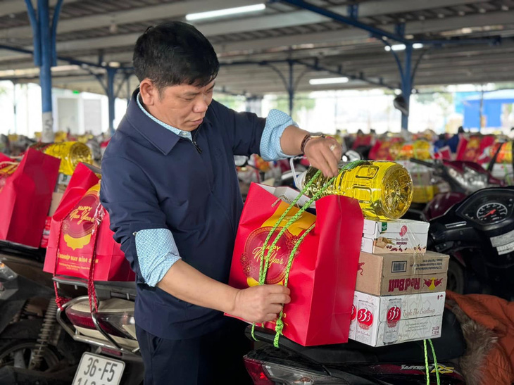 Lãnh đạo xí nghiệp may cũng đích thân buộc quà Tết cho công nhân Thanh Hóa - Ảnh: HƯƠNG ĐẶNG